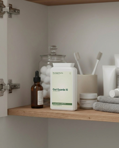 Bottle of 'Gut Guards 10' on a bathroom shelf with various items.
