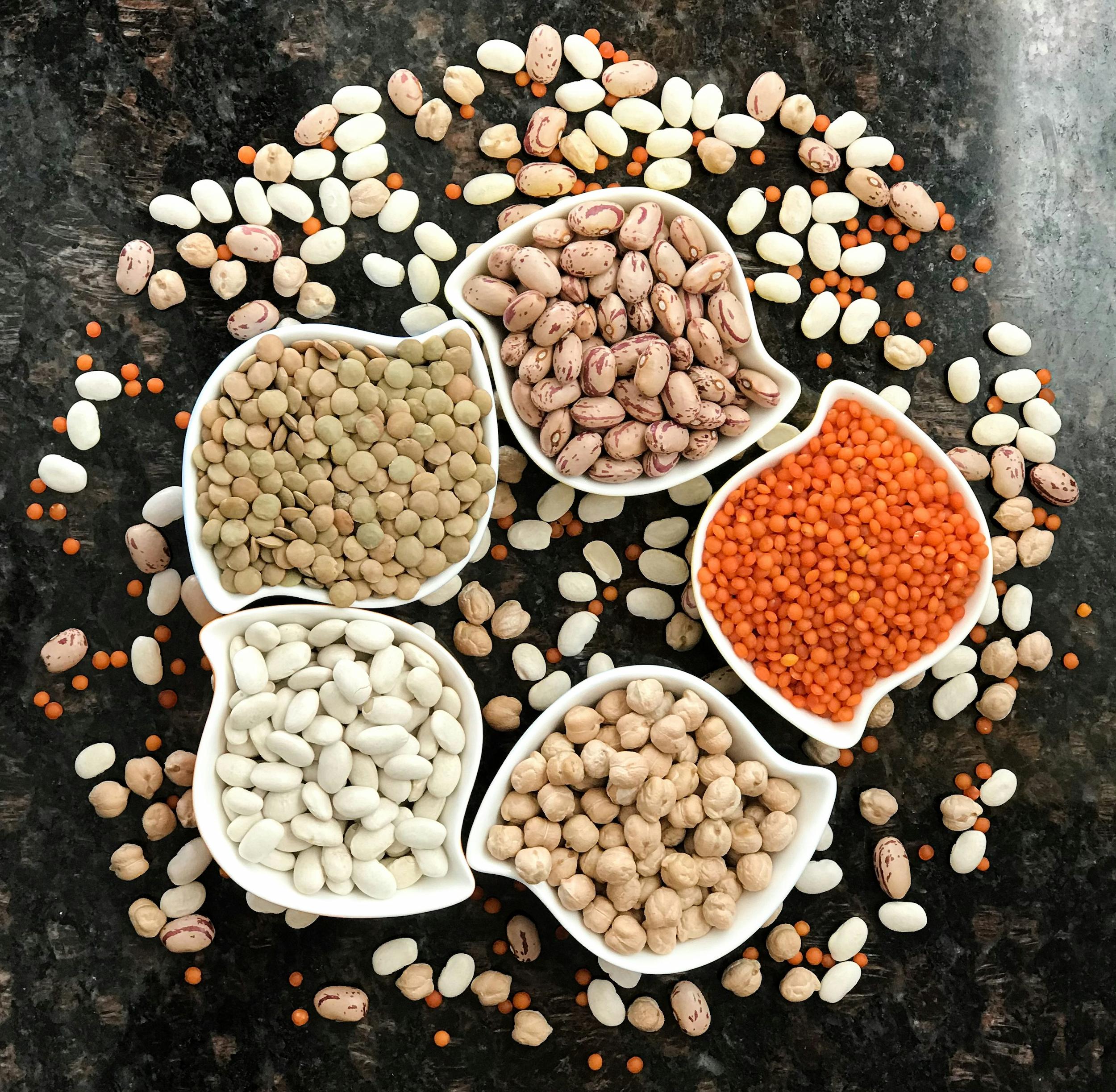 Assortment of high-fibre fruits, vegetables, legumes and wholegrains on a wooden surface