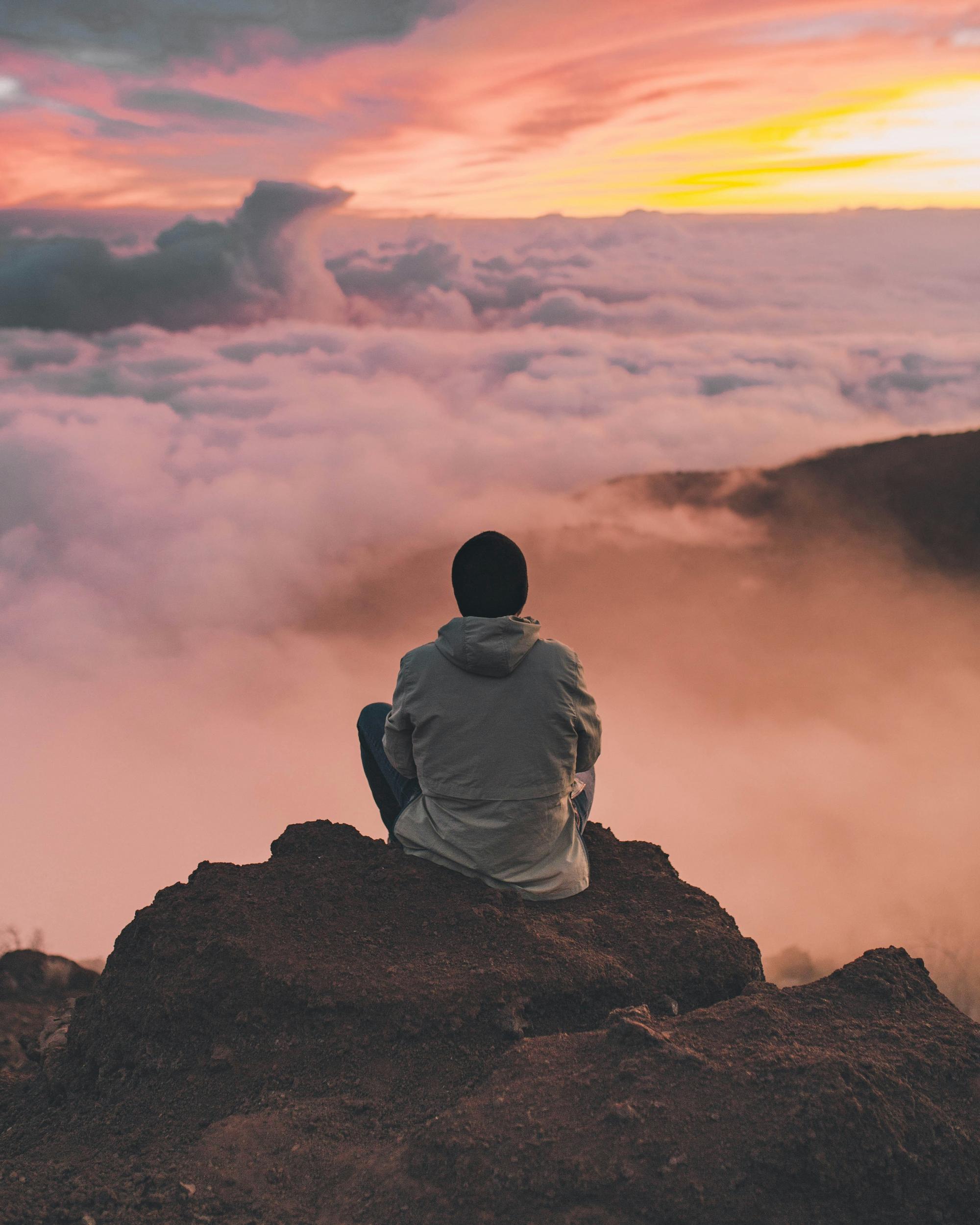 Person practising mindful breathing in a calm, natural setting