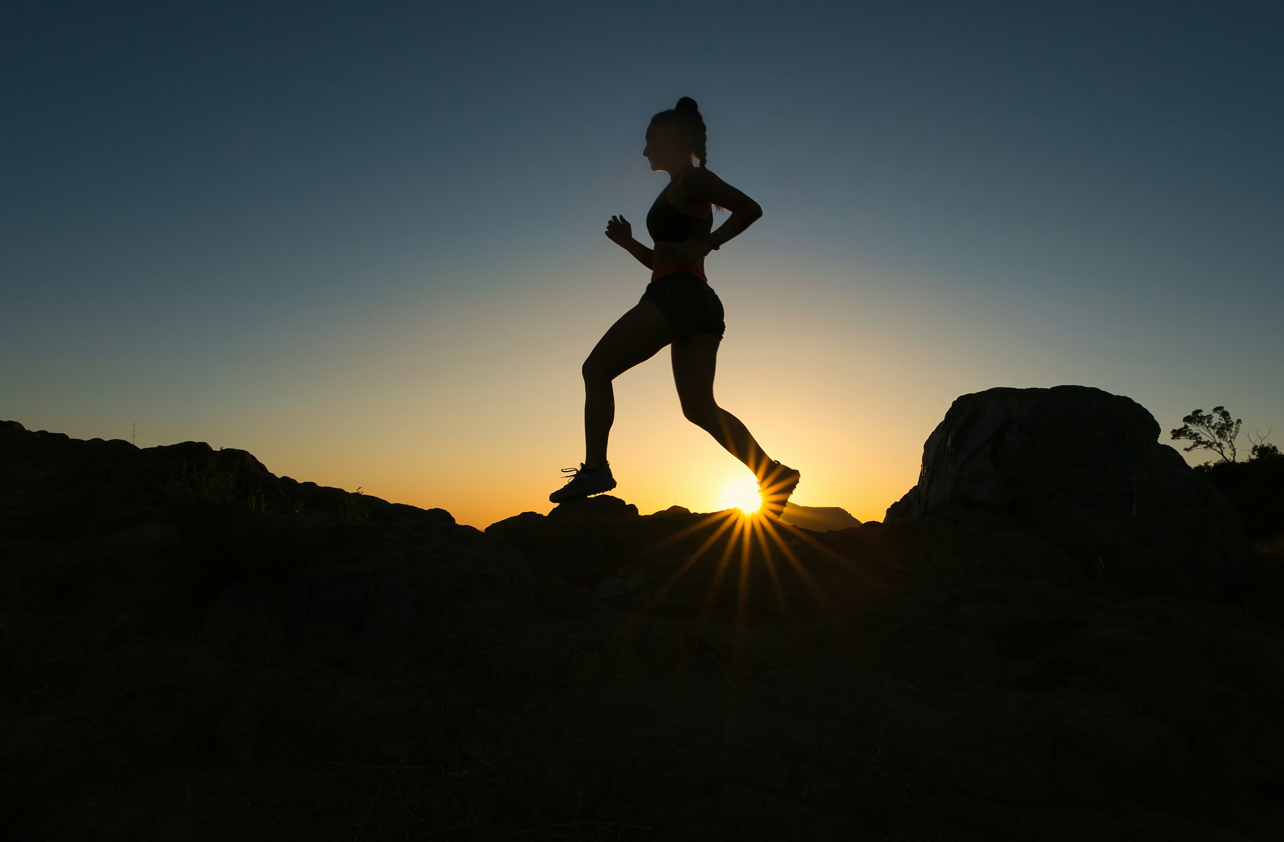 Person jogging outdoors in morning light with a healthy gut concept