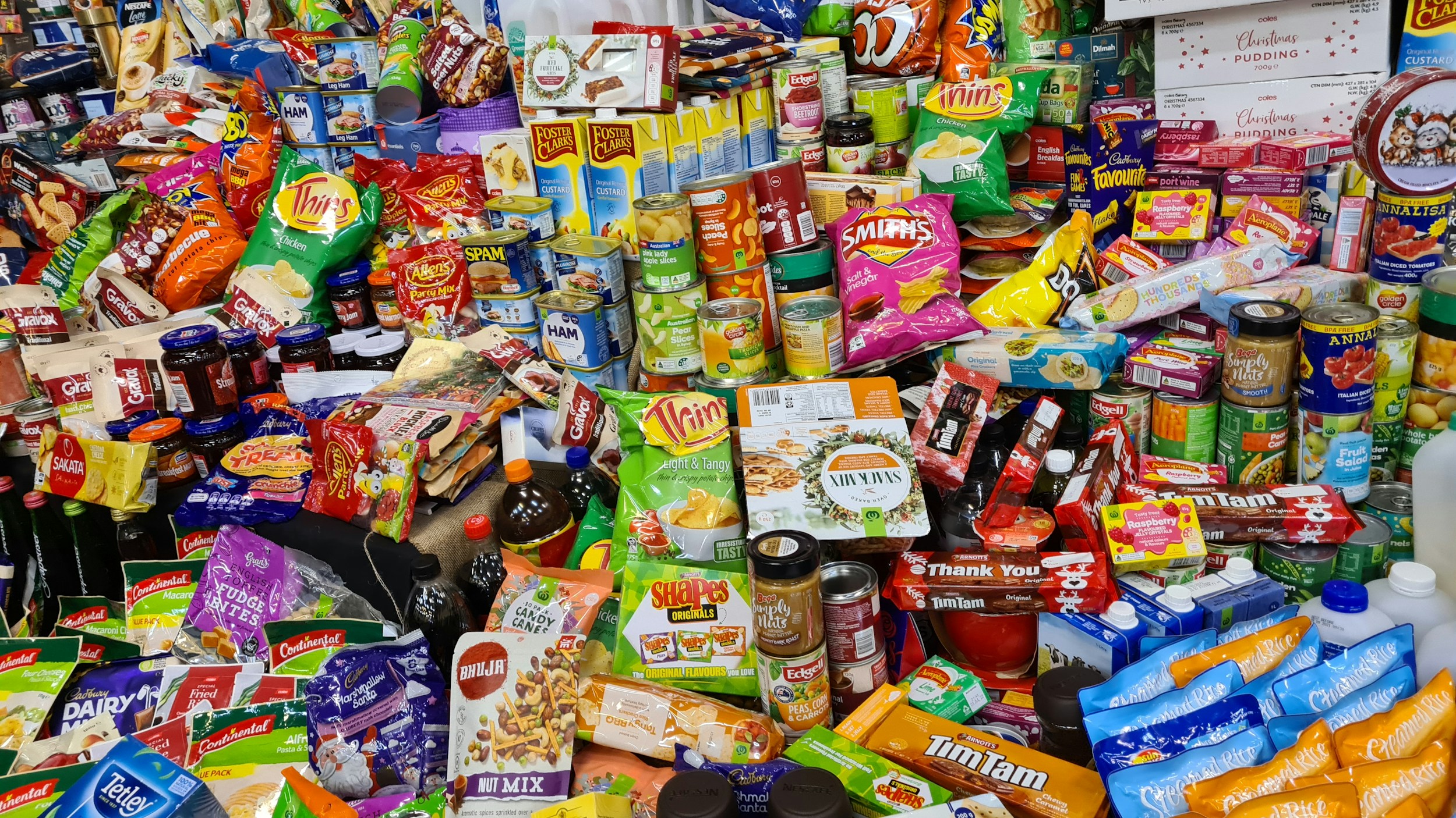 Colourful ultra-processed snack foods and packaged products laid out on a table